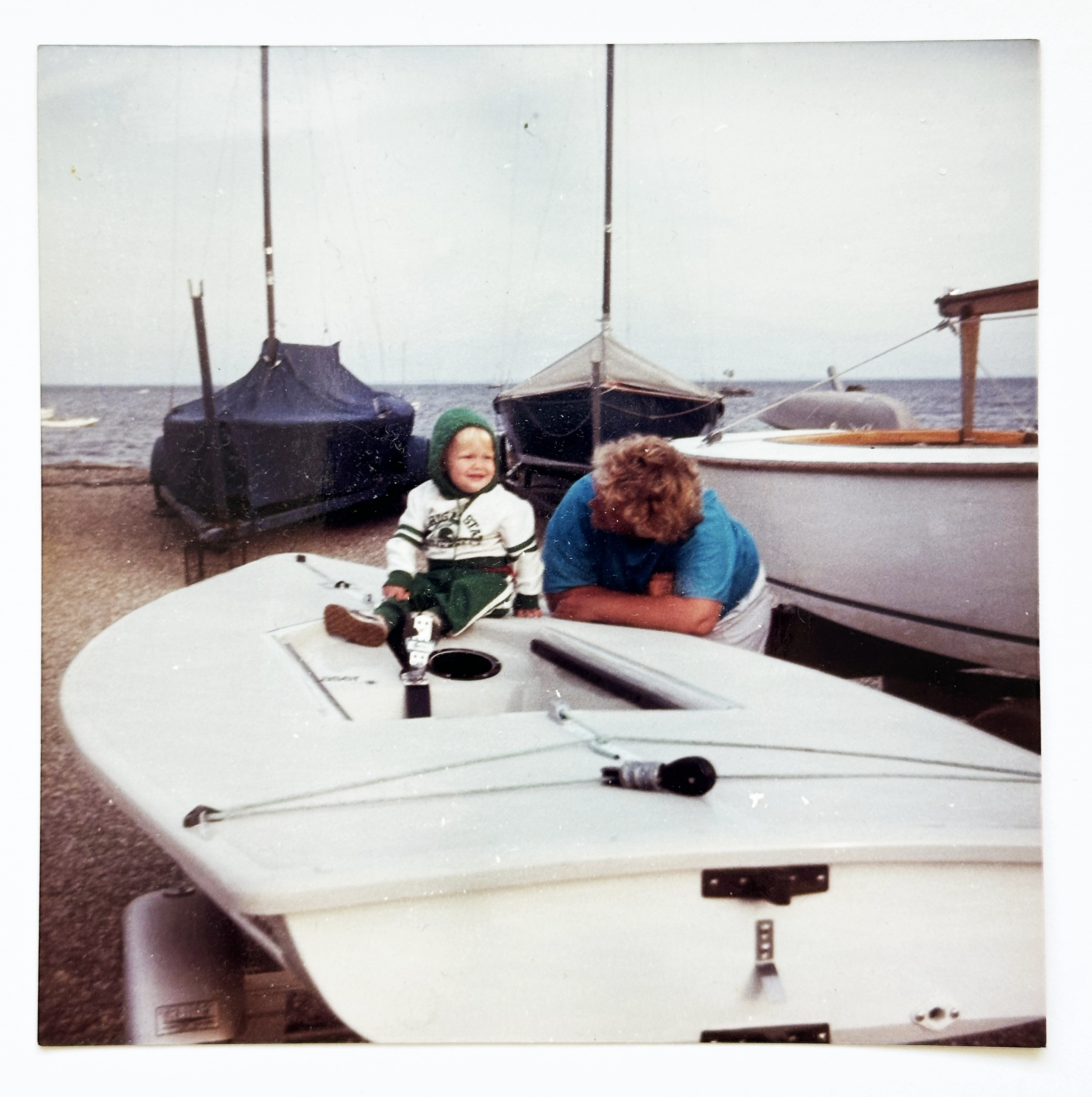 Andrew as a baby sitting on a dinghy at the yacht club